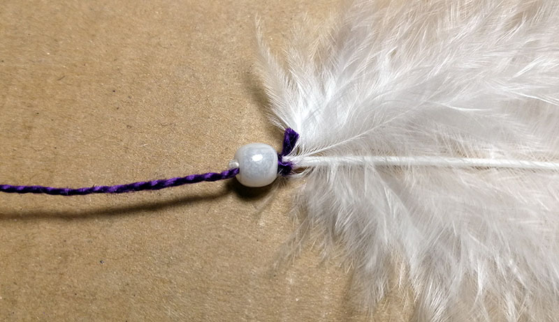 Connecting the yarn to the feather.